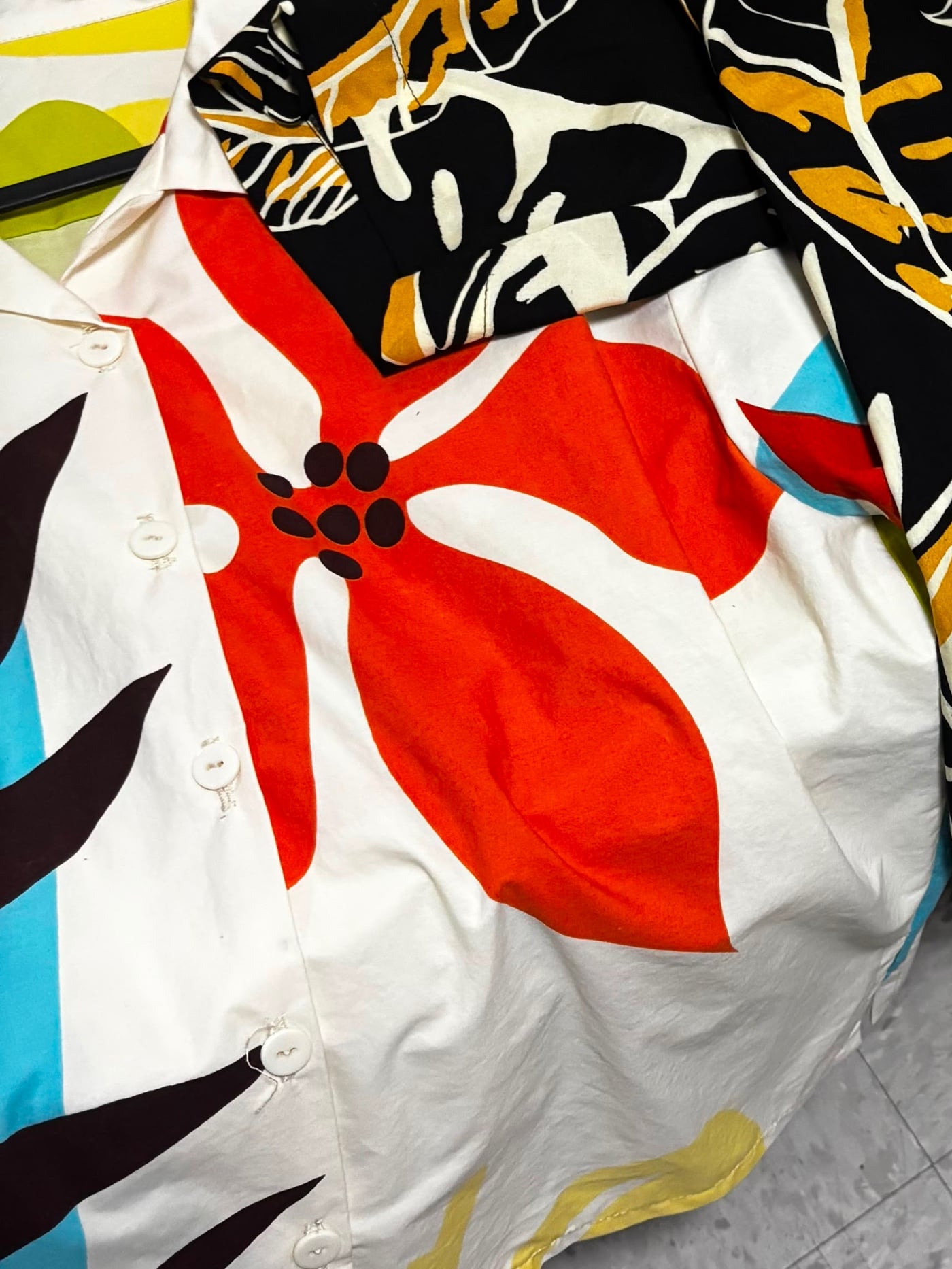 La camisa campera Amapola en algodón crema con una flor naranja grande, recién hecha en el taller.